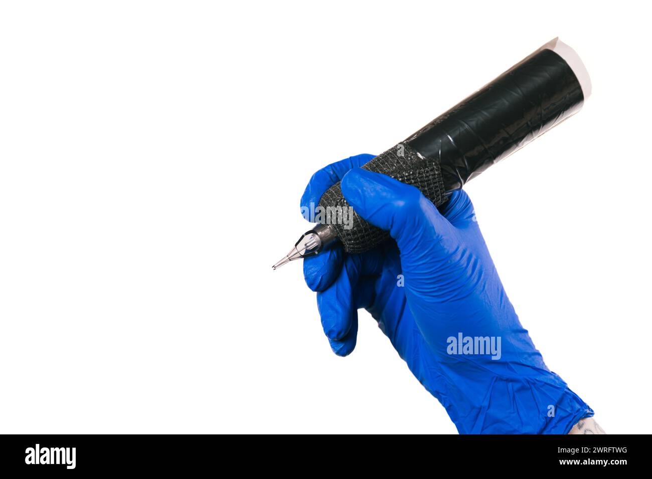 Photo horizontale tatouage la main de l'artiste dans un gant bleu saisit une machine à tatouer, isolée sur blanc, symbolisant la disponibilité à créer Copier l'espace. Conc Banque D'Images