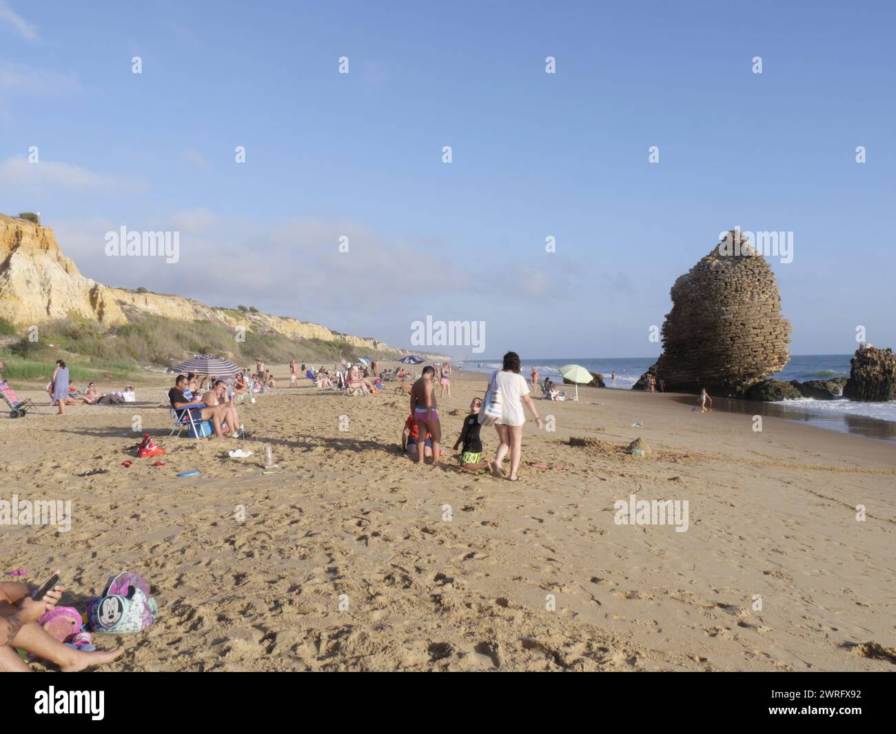 Les amateurs de plage par un après-midi ensoleillé près des ruines de la tour de guet appelée Torre del Rio de Oro, Palos de la Frontera, Espagne, octobre 2023 Banque D'Images