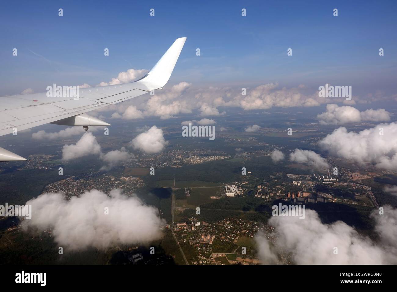 Belle vue sur la terre depuis la fenêtre d'avion supersonique de passager volant haut dans le ciel au-dessus des nuages blancs Banque D'Images