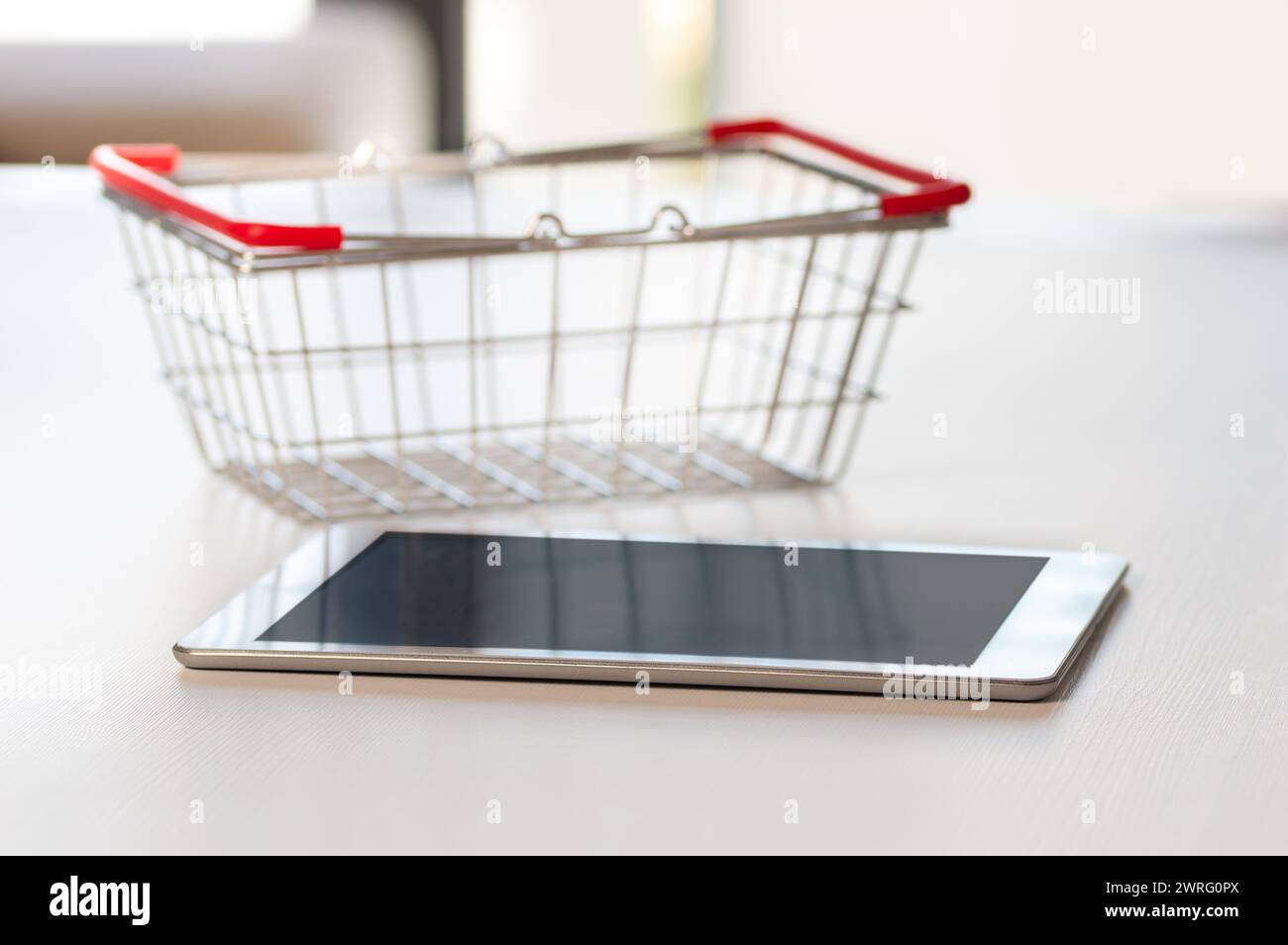Tablette et petit chariot sur table. Concept d'achat sur Internet Banque D'Images