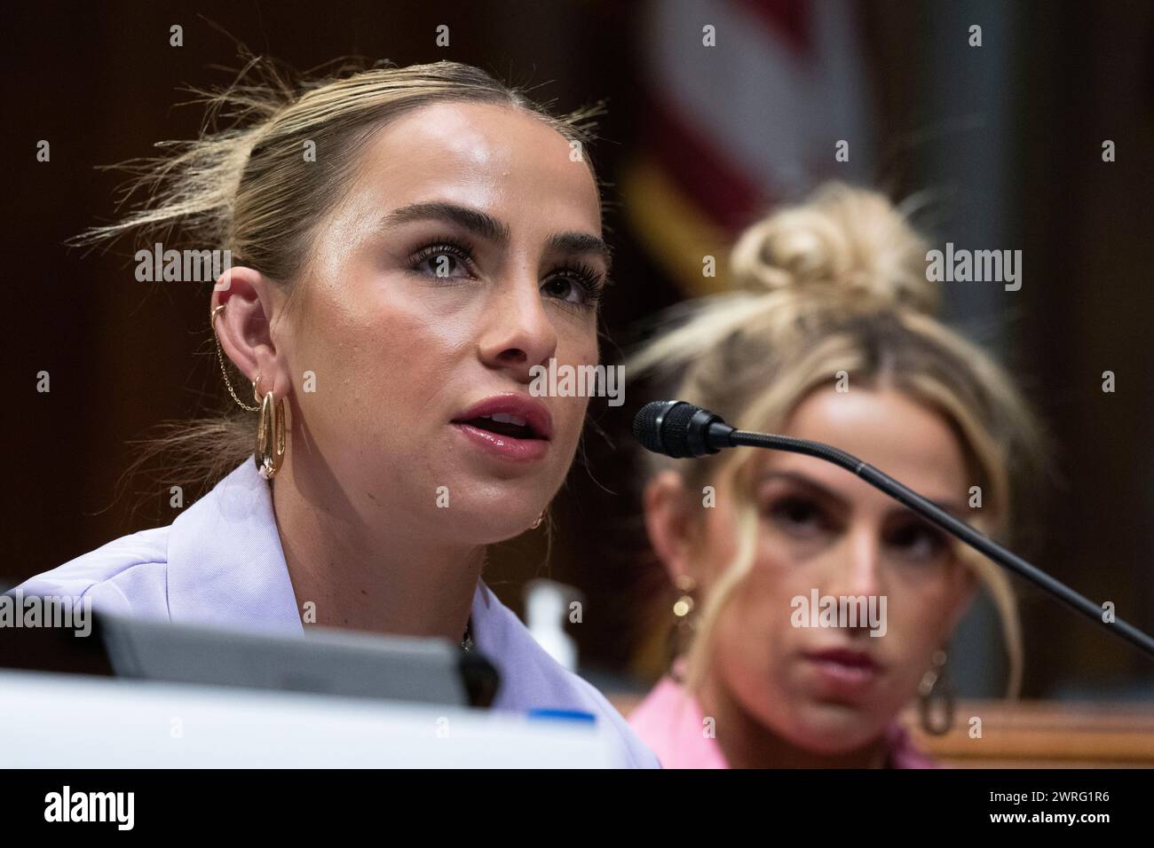 Former University of Miami student athlete Hanna Cavinder speaks as her twin sister TCU student athlete Haley Cavinder listens during a roundtable on the future of college athletics and the need to codify name, image and likeness rights for student athletes, on Capitol Hill, Tuesday, March 12, 2024, in Washington. (AP Photo/Manuel Balce Ceneta) Banque D'Images