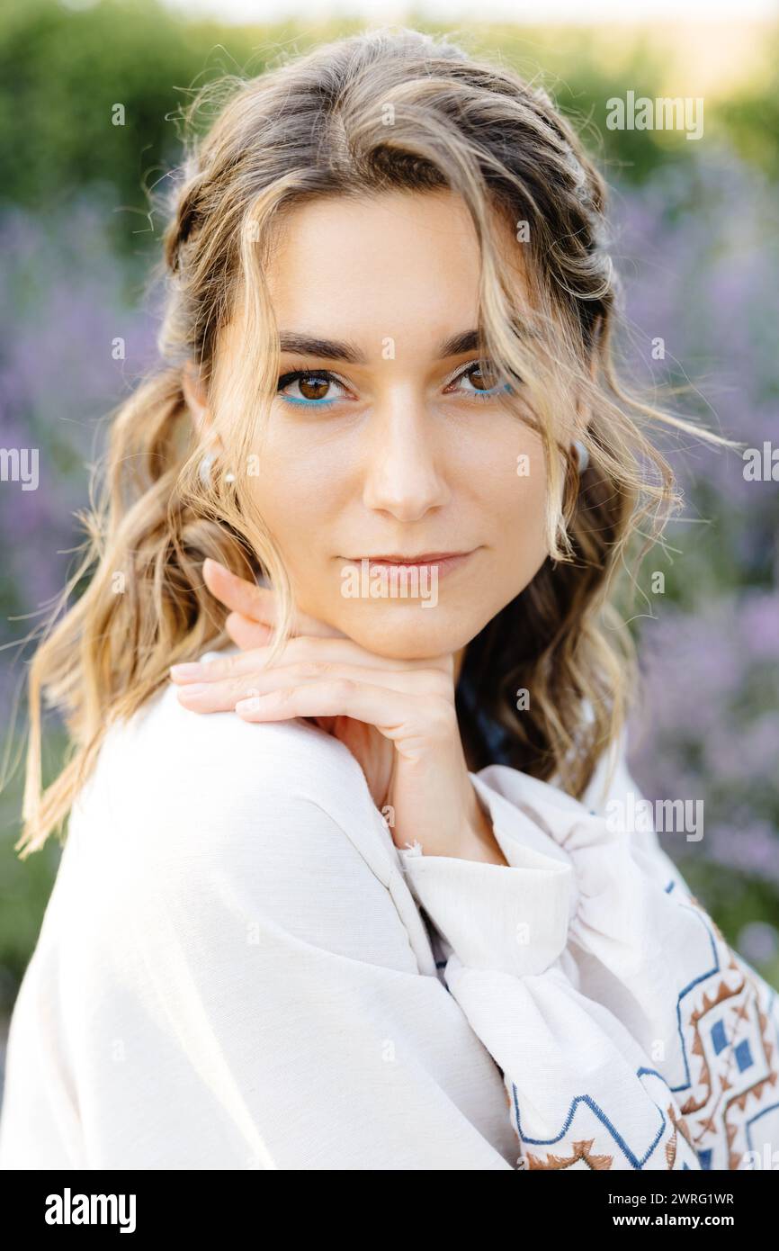 Une femme aux cheveux longs portant une chemise blanche est représentée dans la scène. Elle respire la simplicité et l'élégance dans sa tenue vestimentaire. Banque D'Images