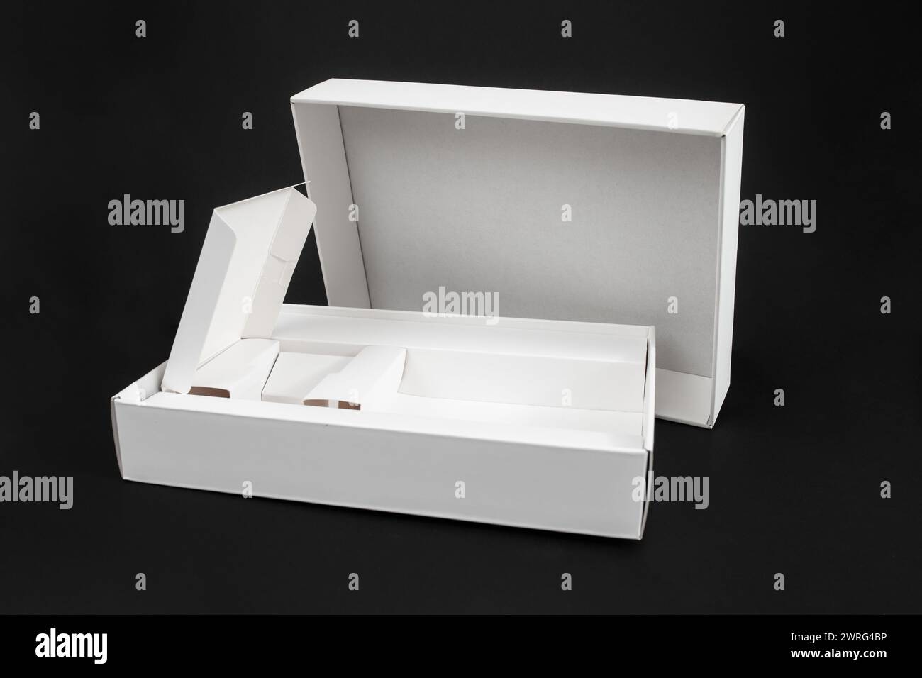 Boîte vide pour smartphone ou tablette, emballage en carton blanc isolé sur fond noir Banque D'Images