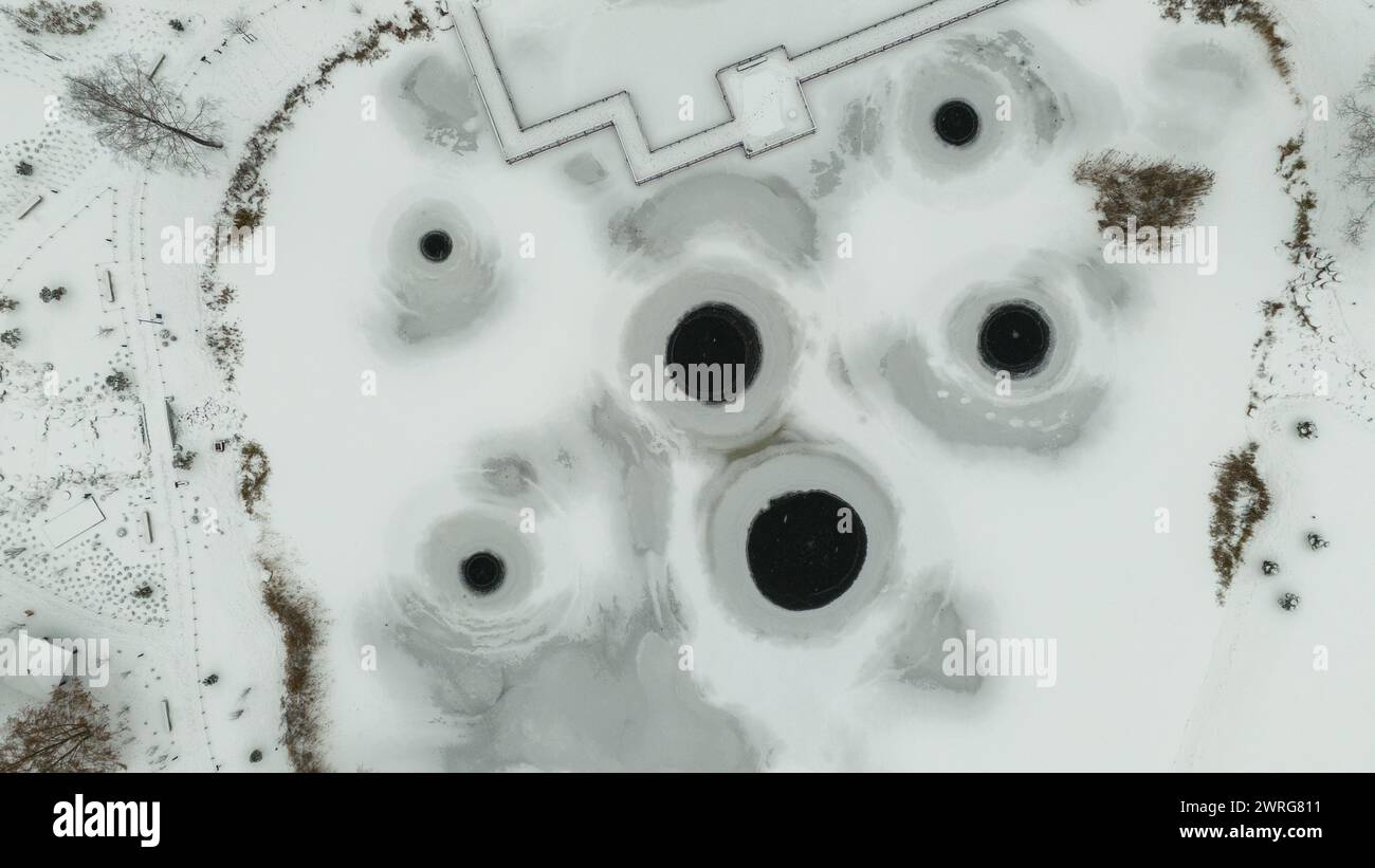Photographie par drone d'un lac gelé et d'une machine pompant de l'air afin que le lac ne gèle pas pendant la journée nuageuse d'hiver Banque D'Images