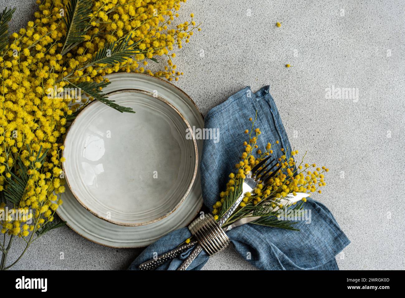 Vue de dessus d'un cadre de lieu avec des fleurs de mimosa jaunes sur une table Banque D'Images