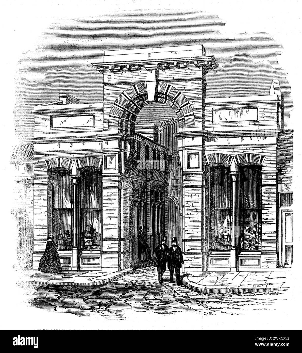 Entrée au Agricultural Hall depuis High-Street, Islington, [Londres], 1862. Site du salon du bétail et des outils du Smithfield Club. « Mille tonnes de fer sont utilisées dans sa construction, et la toiture contient neuf milles de barre de fer, plus d'un acre de verre, et deux acres d'ardoise, tandis que l'espace offert par les galeries est considérablement au-dessus d'un acre. Les tours... sont construites en vue d'aider à la ventilation. Les piliers de fer qui soutiennent les parties centrales du tissu forment des tubes de drainage du toit au sous-sol et les appareils de drainage sous...le buil Banque D'Images