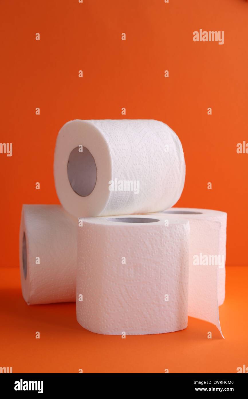 Rouleaux de papier toilette doux sur fond orange, gros plan Banque D'Images