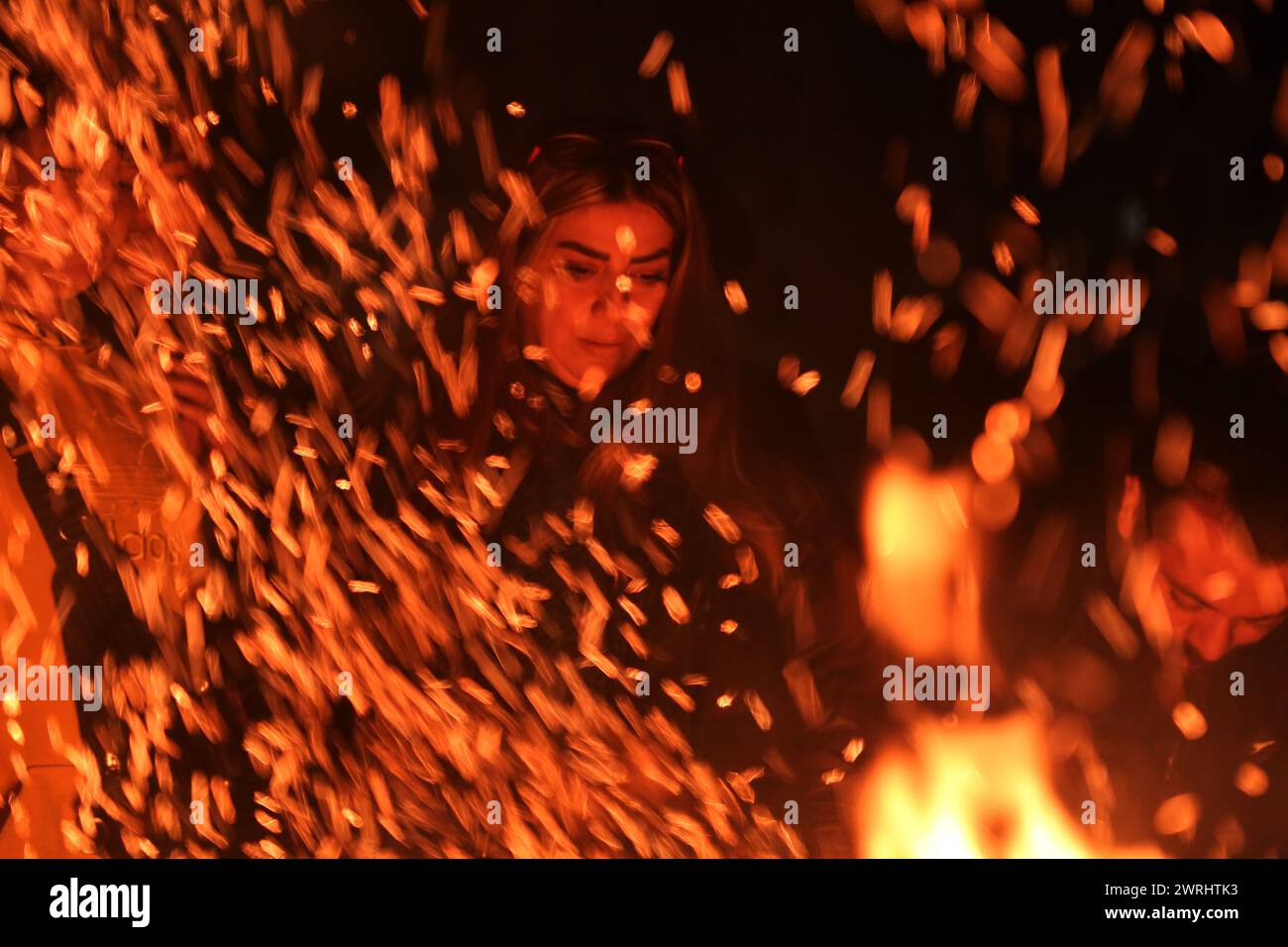 Téhéran, Iran. 12 mars 2024. Une femme iranienne regarde un feu de joie la veille de la traditionnelle fête du feu de mercredi, ou Chaharshanbeh Soori, qui a lieu chaque année la dernière veille de mercredi avant la fête du printemps de Nowruz, à Téhéran. Le nouvel an iranien (Nowruz), qui commence le 20 mars, coïncide avec le premier jour du printemps au cours duquel les habitants ravivent la célébration zoroastrienne de l’allumage d’un feu et de la danse autour de la flamme. (Crédit image : © Rouzbeh Fouladi/ZUMA Press Wire) USAGE ÉDITORIAL SEULEMENT! Non destiné à UN USAGE commercial ! Banque D'Images