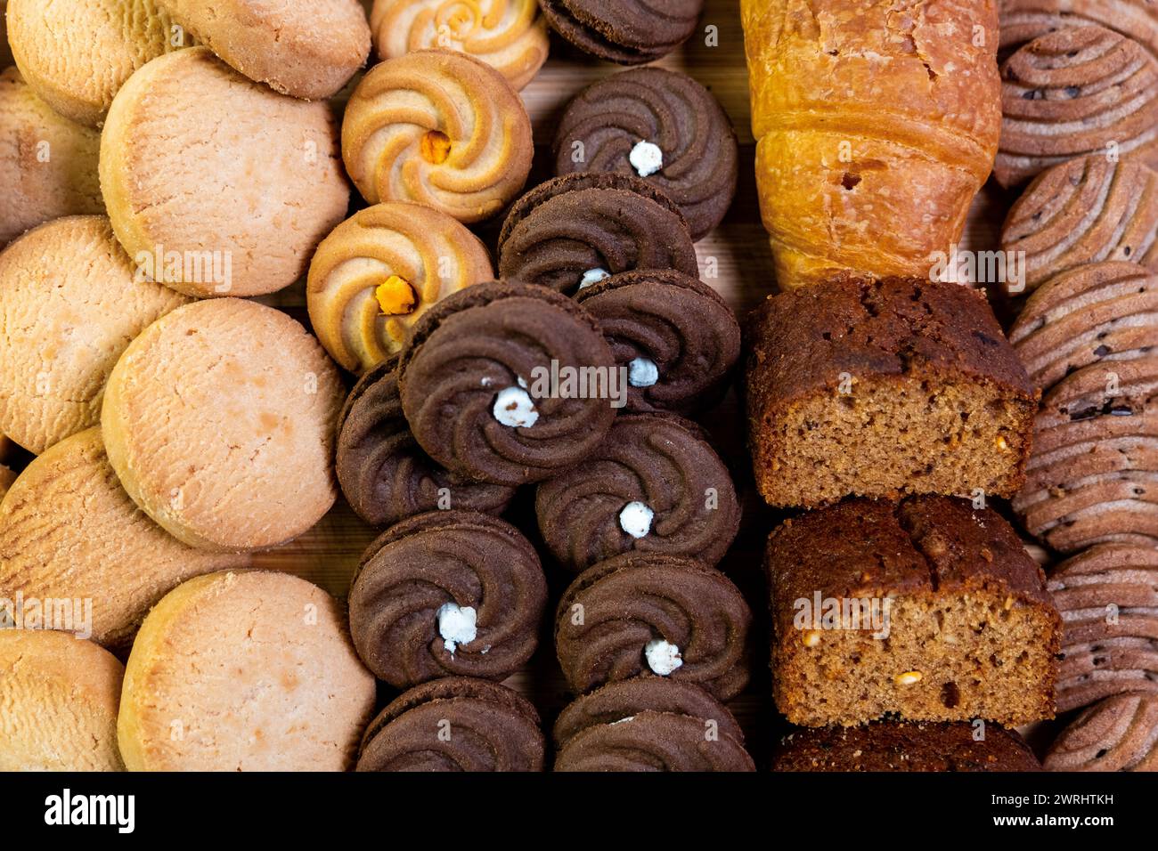 Cette image alléchante présente un assortiment alléchant de produits de boulangerie, disposés sur une planche de bois rustique pour une vue rapprochée ravissante. Banque D'Images