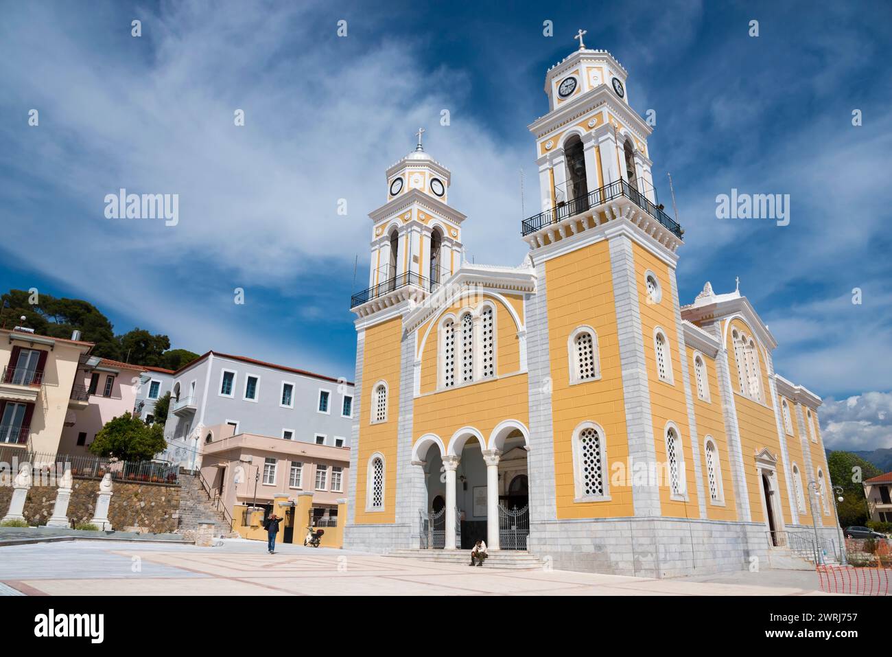 Une église jaune avec deux tours d'horloge sous un ciel bleu, devant une place pavée, cathédrale, Ypapantis Sotiros, Kalamata, Messinia, Péloponnèse Banque D'Images