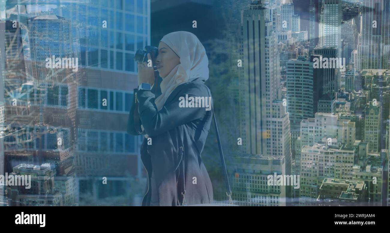 Image d'une femme asiatique en hijab avec caméra au-dessus du paysage urbain Banque D'Images