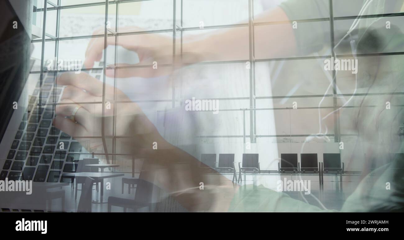 Image de mains d'un homme utilisant un ordinateur portable sur des navetteurs accélérés marchant dans un bâtiment moderne Banque D'Images