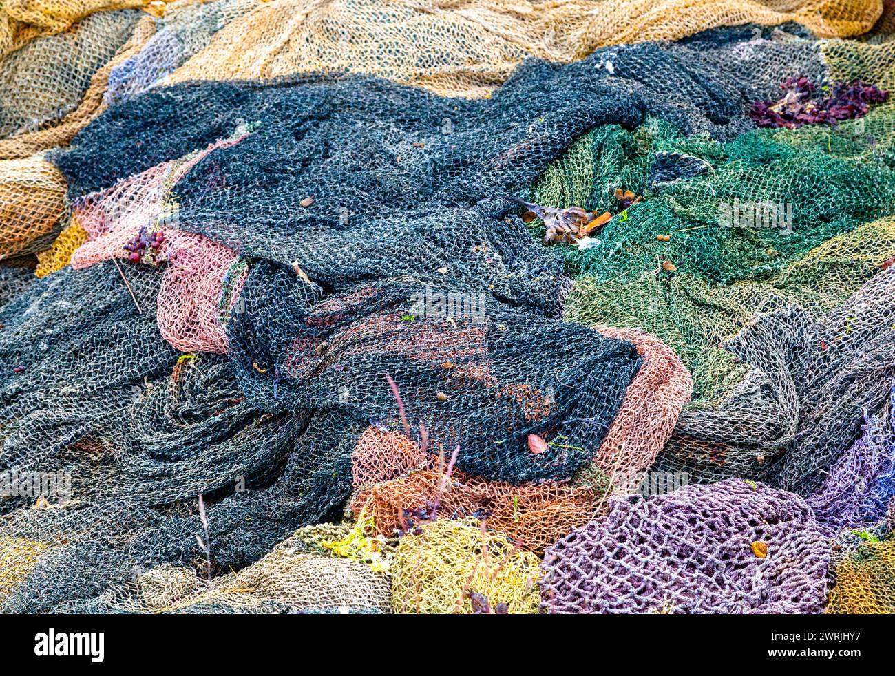 Filets de pêche colorés abandonnés sur un cimetière de bateaux Banque D'Images