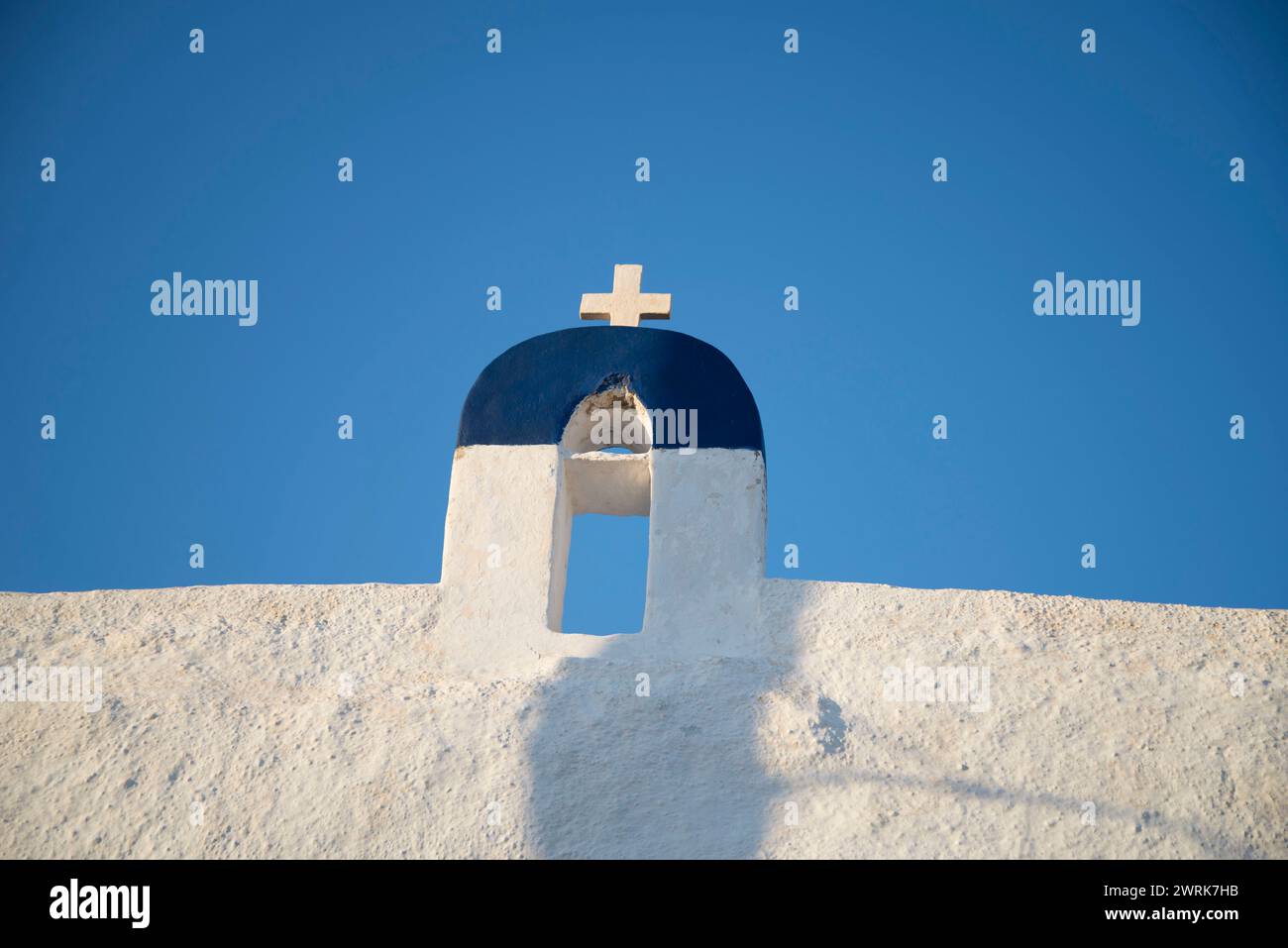 Un clocher blanc avec une croix contre un ciel bleu Banque D'Images