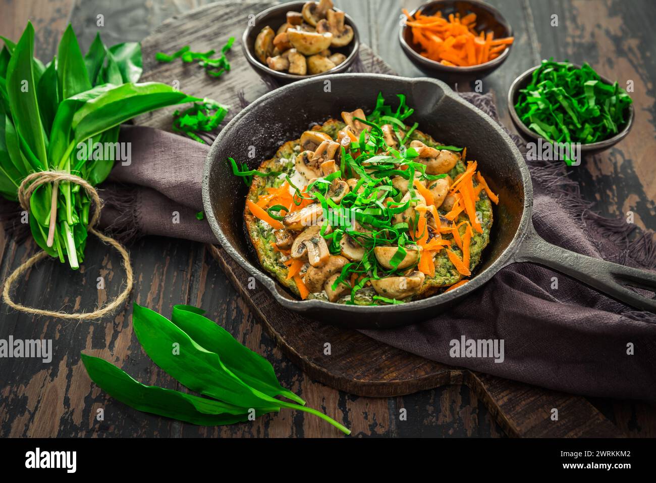 Quiche végétarienne ou crêpe cuite au four avec ramson, carottes et champignons. Banque D'Images