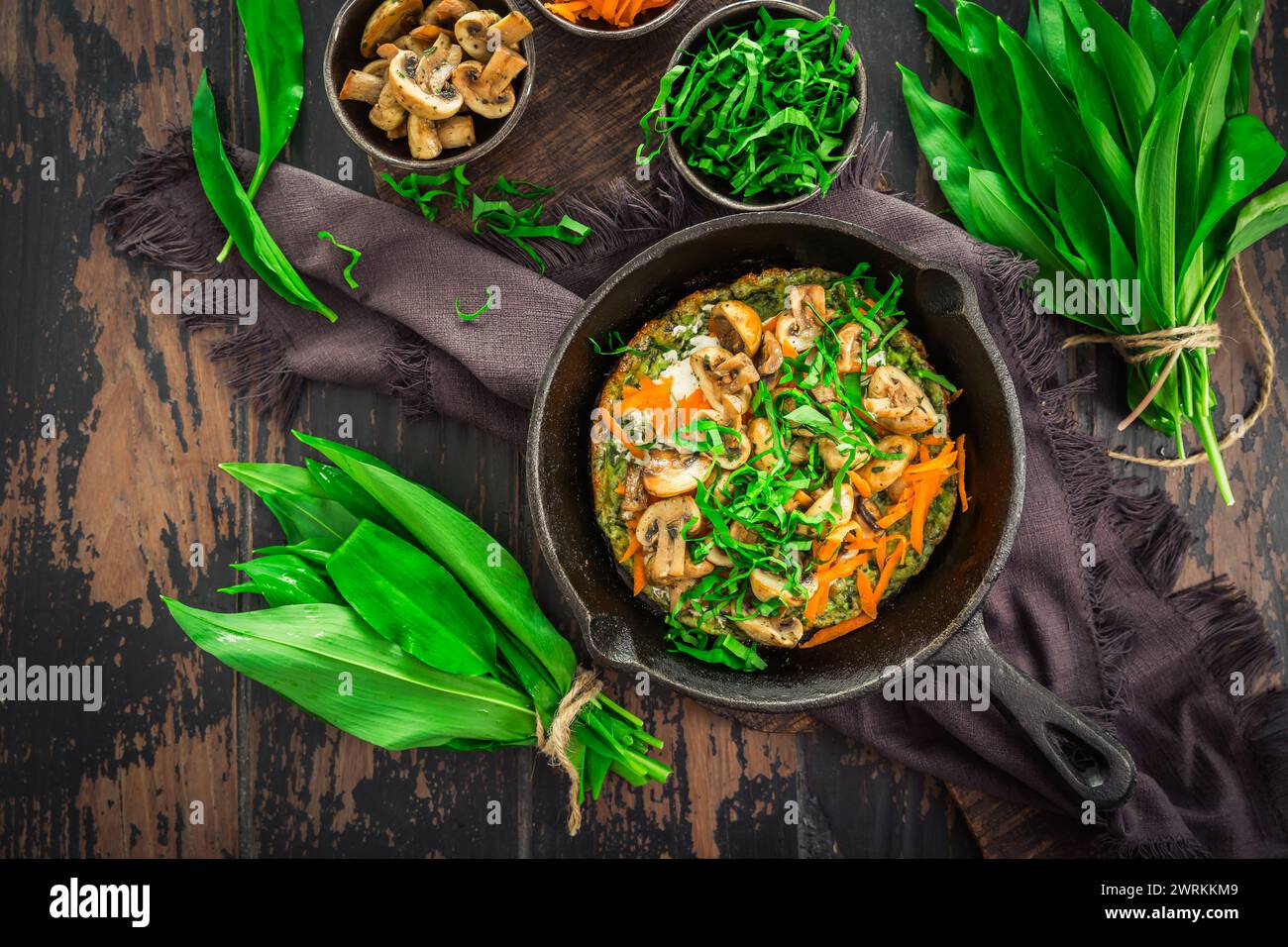 Quiche végétarienne ou crêpe cuite au four avec ramson, carottes et champignons. Banque D'Images
