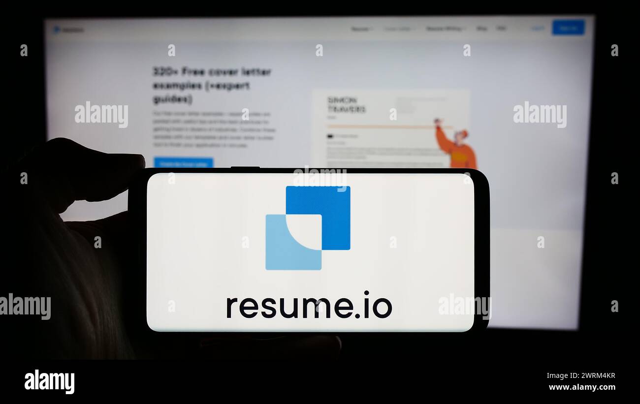 Personne tenant le téléphone portable avec le logo de la société néerlandaise de création de CV Resume.io devant la page Web de l'entreprise. Concentrez-vous sur l'affichage du téléphone. Banque D'Images