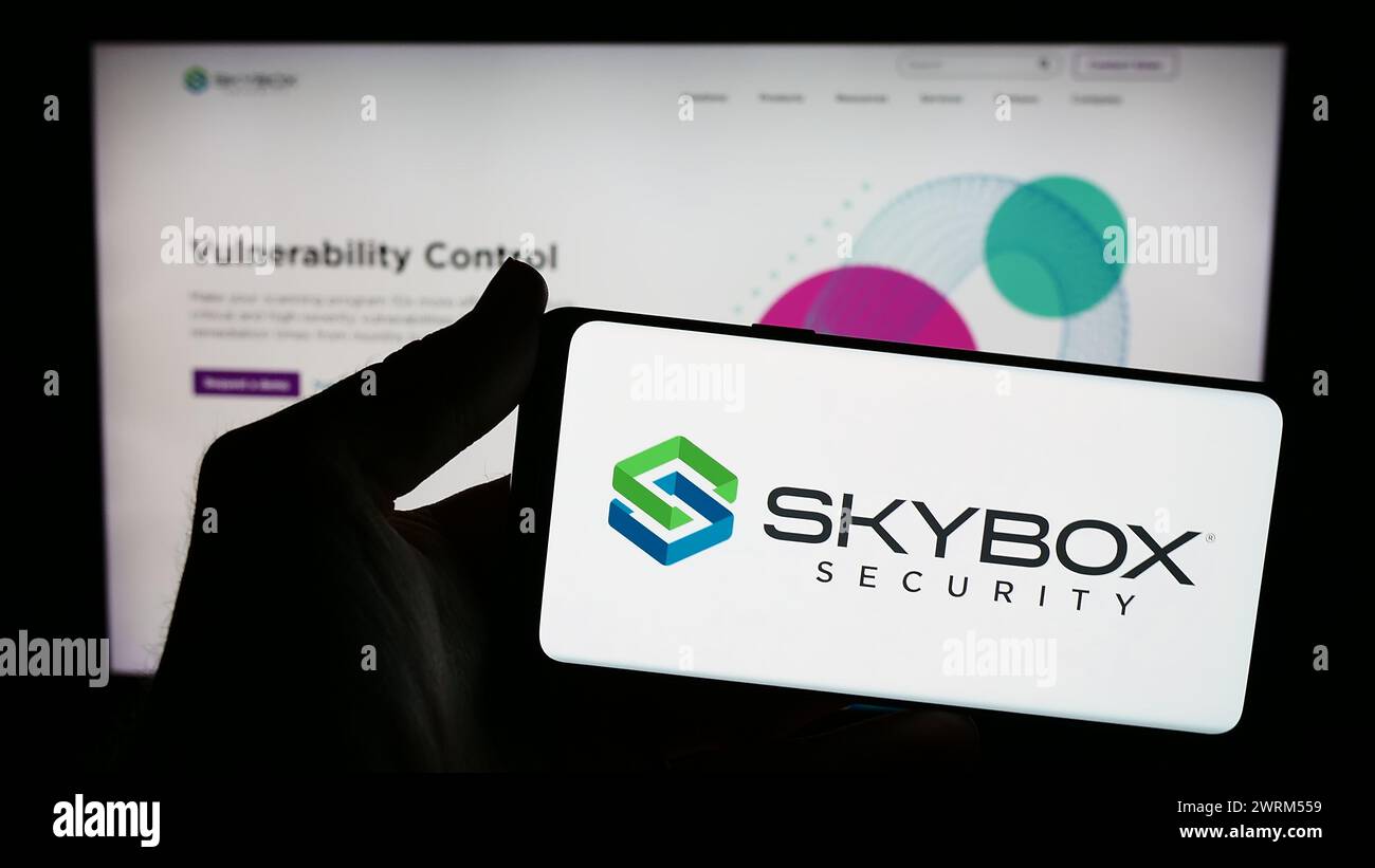 Personne tenant un smartphone avec le logo de la société américaine de cybersécurité Skybox Security Inc en face du site Web. Concentrez-vous sur l'affichage du téléphone. Banque D'Images