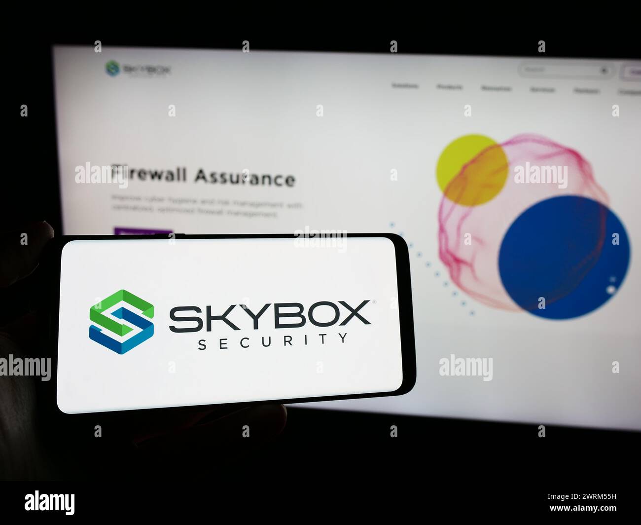 Personne tenant le téléphone portable avec le logo de la société américaine de cybersécurité Skybox Security Inc en face de la page Web. Concentrez-vous sur l'affichage du téléphone. Banque D'Images