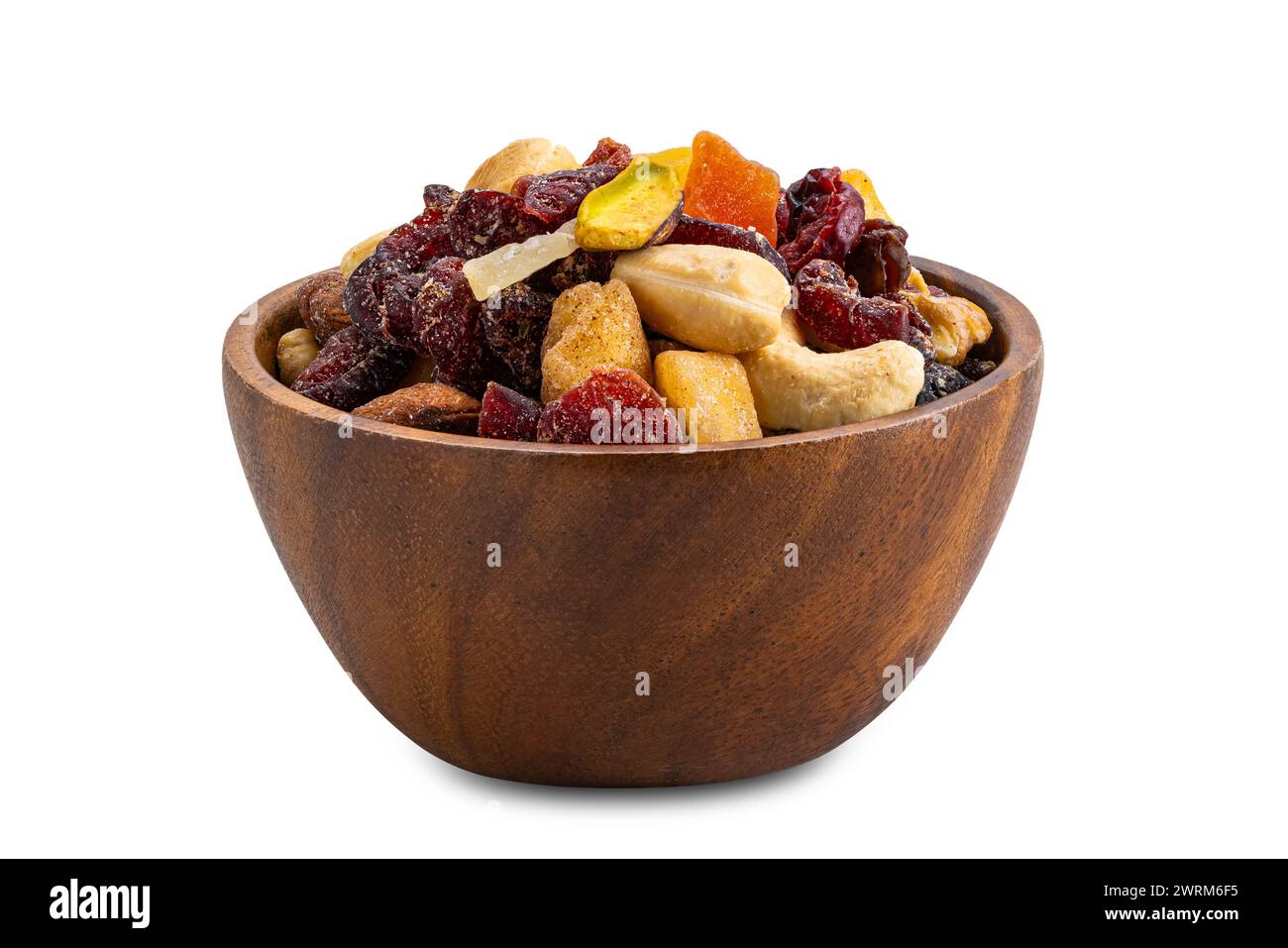 Gros plan du petit déjeuner mélanger noix et fruits dans un bol en bois isolé sur fond blanc avec chemin de découpage. Banque D'Images