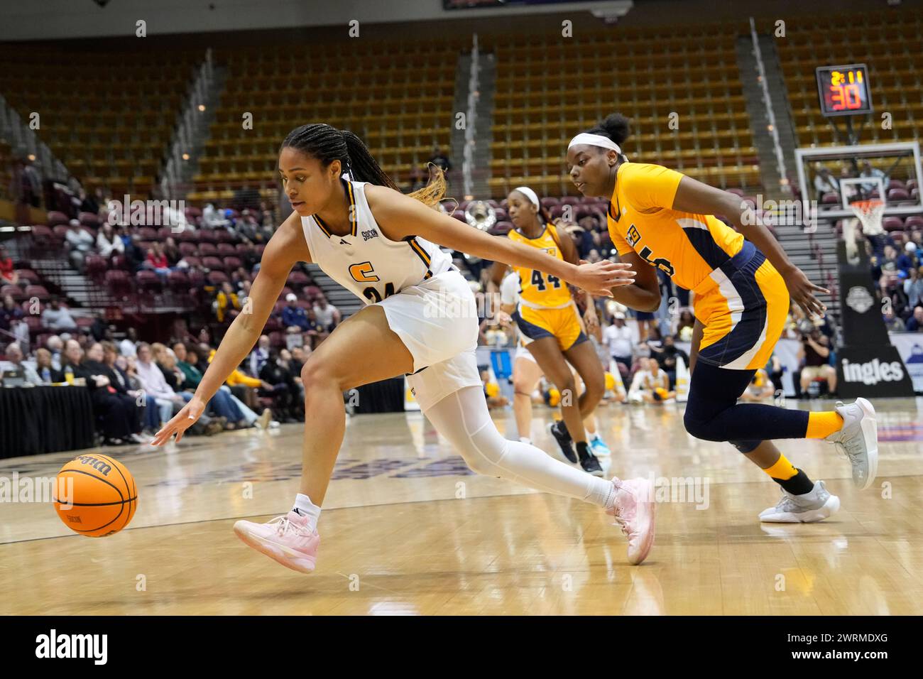 Chattanooga guard Jada Guinn (24) chases a loose ball ahead of UNC Greensboro forward Khalis Cain (15) during an NCAA women's college basketball championship game for the Southern Conference tournament, Sunday, March 10, 2024, in Asheville, N.C. (AP Photo/Kathy Kmonicek) Banque D'Images
