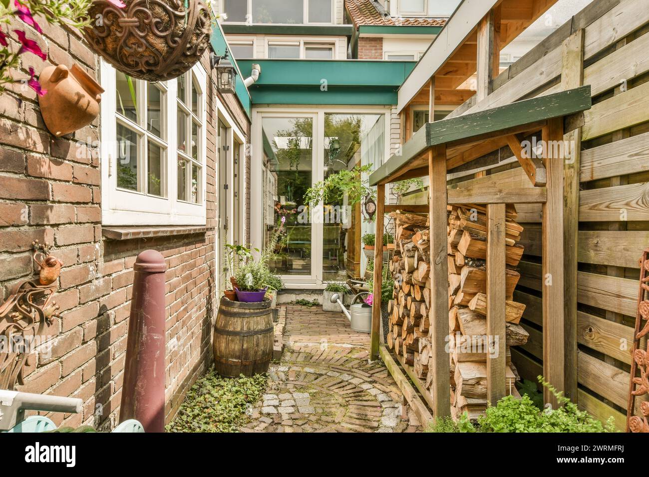 Une ruelle pittoresque dans un village européen avec un chemin pavé, une végétation luxuriante et des accents en bois rustiques. Banque D'Images