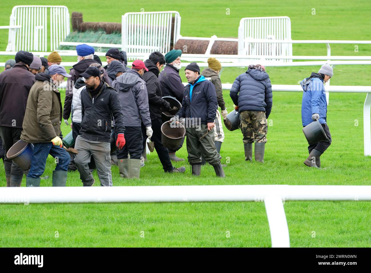 Hippodrome de Cheltenham, Gloucestershire Royaume-Uni - mercredi 13 mars 2024 - le personnel au sol vérifie la surface du gazon de l'hippodrome et comble les trous dans l'herbe avant le début du deuxième jour du Festival de Cheltenham de cette année. Photo Steven May / Alamy Live News Banque D'Images