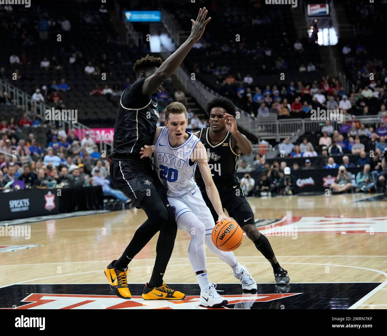 13 MARS 2024 : Spencer Johnson (20 ans), garde des jeunes Cougars de Brigham, conduit entre deux défenseurs de l'UCF lors du Big 12 Championship Tournament au T-Mobile Center, Kansas City, Missouri. Jon Robichaud/CSM. Banque D'Images