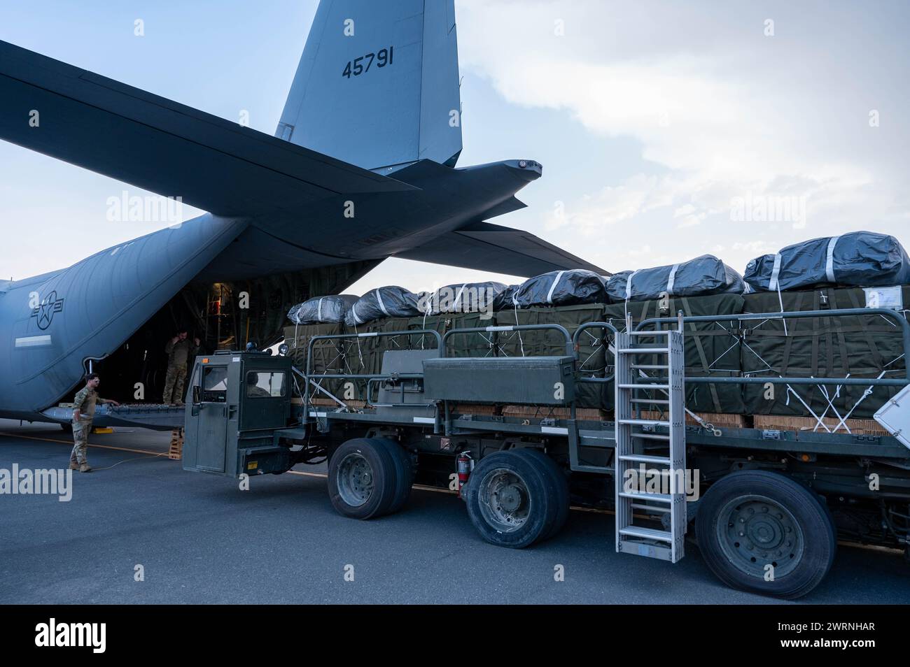 Zarqa, Jordanie. 11 mars 2024. Un capitaine de chargement de l'US Air Force positionne des palettes d'aide humanitaire pour le chargement dans la soute d'un avion C-130J Super Hercules de l'US Air Force à la base aérienne King Abdullah II, le 11 mars 2024 à Zarqa, gouvernorat de Zarqa, Jordanie. L’aide alimentaire sera larguée par voie aérienne aux réfugiés palestiniens pris au piège de la guerre israélienne contre le Hamas. Crédit : A1C Caleb Parker/US Airforce photo/Alamy Live News Banque D'Images