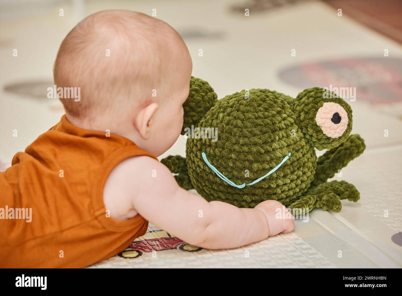 bébé joue avec un jouet tricoté dans la pépinière Banque D'Images