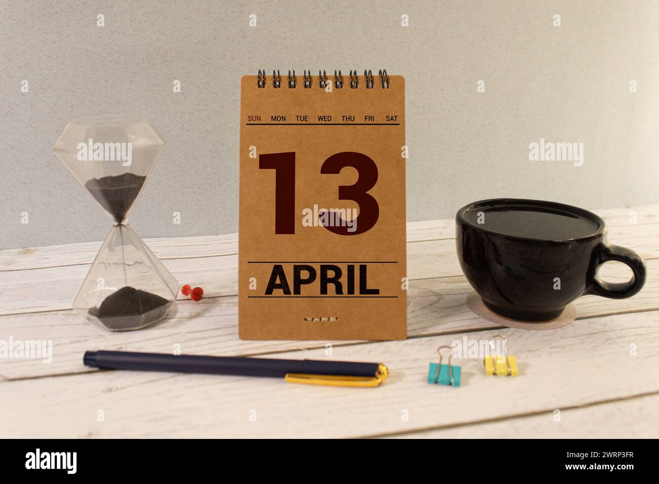 13 avril. Jour 13 du mois, calendrier sur table en bois et fond violet. Heure du printemps, espace vide pour le texte Banque D'Images