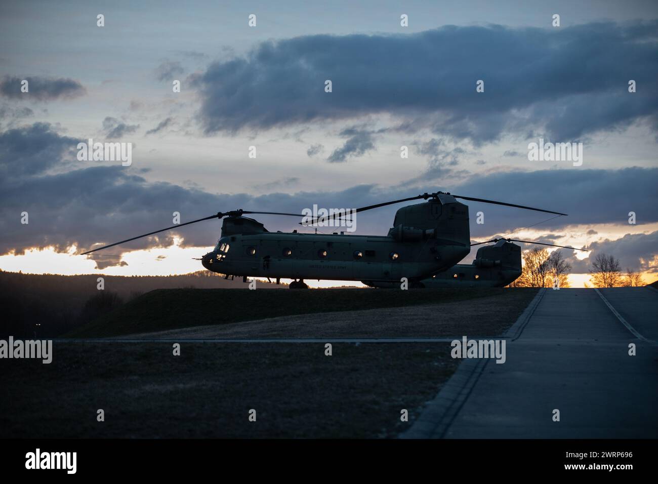 Le soleil se couche sur un Chinook UH-47 soutenant des opérations aériennes près de Hohenfels, en Allemagne, le 11 mars 2024, dans le cadre de Allied Spirit 24. Allied Spirit 24 est un exercice de l'armée américaine conçu pour préparer les initiatives de dissuasion des Alliés et des partenaires de l'OTAN par le biais d'une gamme d'activités militaires conjointes et multinationales au Centre de préparation multinationale mixte près de Hohenfels, en Allemagne. Dans le cadre de l'exercice mondial à grande échelle 2024 du Département de la Défense des États-Unis, Allied Spirit prépare les forces multinationales à agir de concert pour relever les défis de sécurité à travers le monde. (U.S. Army National Guard photo par Army S Banque D'Images