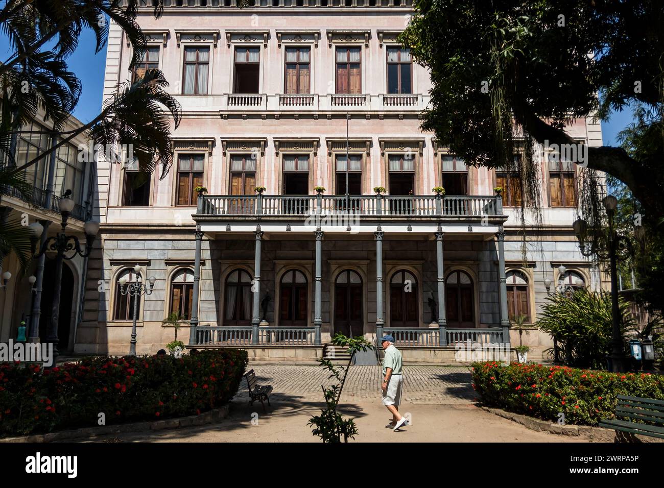 Vue partielle de la célèbre façade du palais Catete face aux jardins de végétation verte intérieure dans le quartier de Flamengo sous le ciel bleu ensoleillé du matin d'été. Banque D'Images