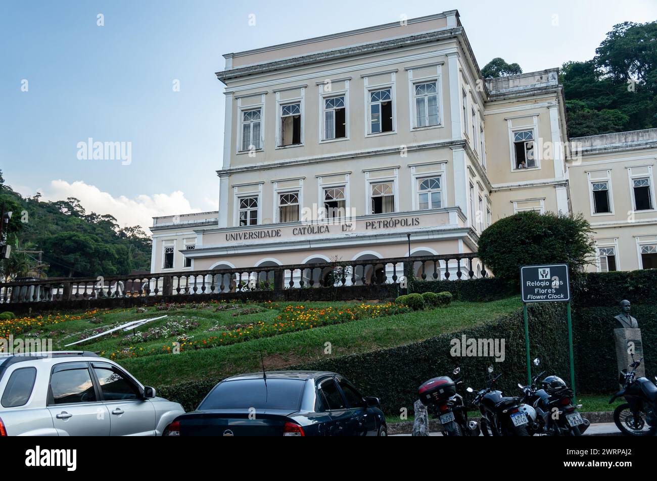 Façade du bâtiment principal de l'Université catholique de Petropolis avec l'horloge de fleur visible ci-dessous sous l'après-midi d'été ciel bleu nuageux. Banque D'Images