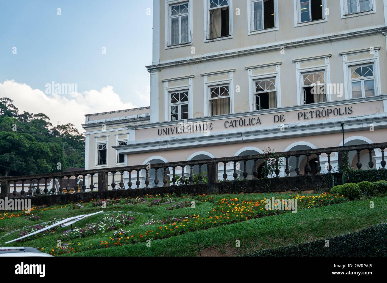 Vue partielle du bâtiment principal de l'Université catholique de Petropolis avec l'horloge de fleur visible ci-dessous sous l'après-midi d'été ciel bleu nuageux. Banque D'Images