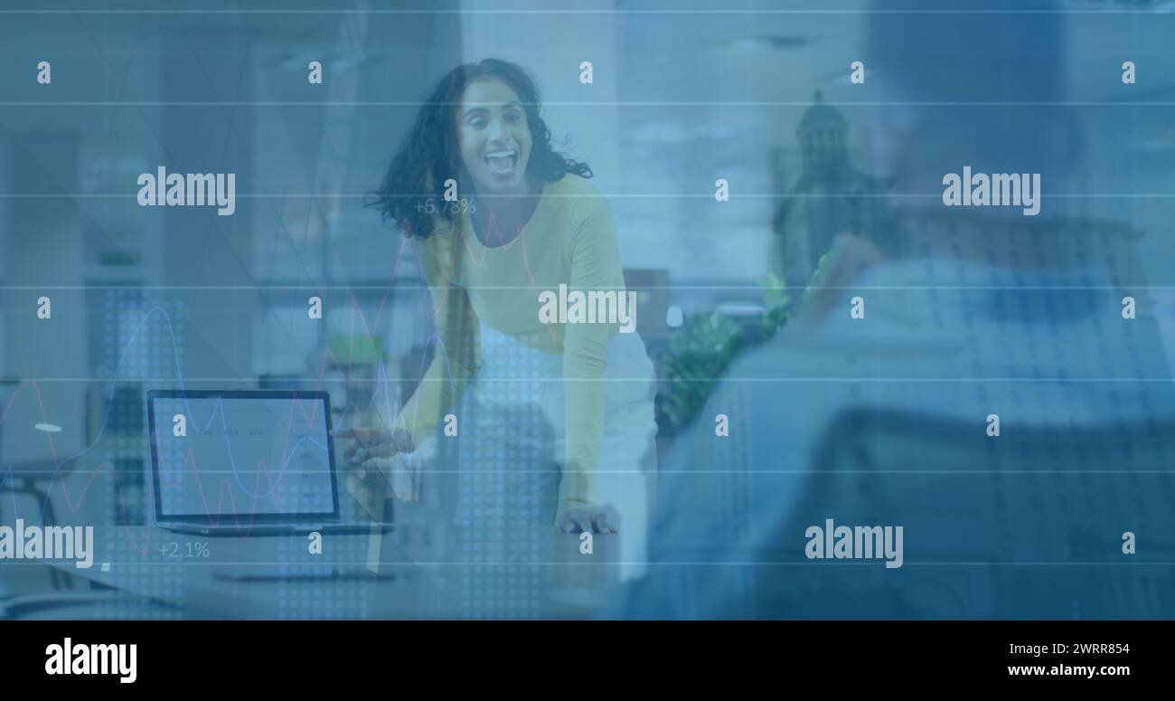 Image de graphiques sur femme biraciale avec ordinateur portable dans le bureau Banque D'Images