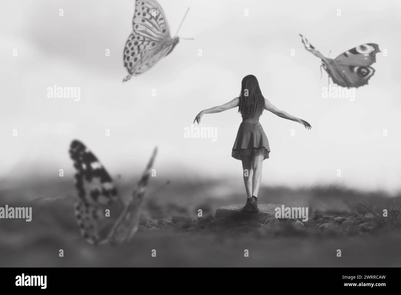 femme marchant joyeusement parmi les papillons géants dansant autour d'elle, concept abstrait Banque D'Images