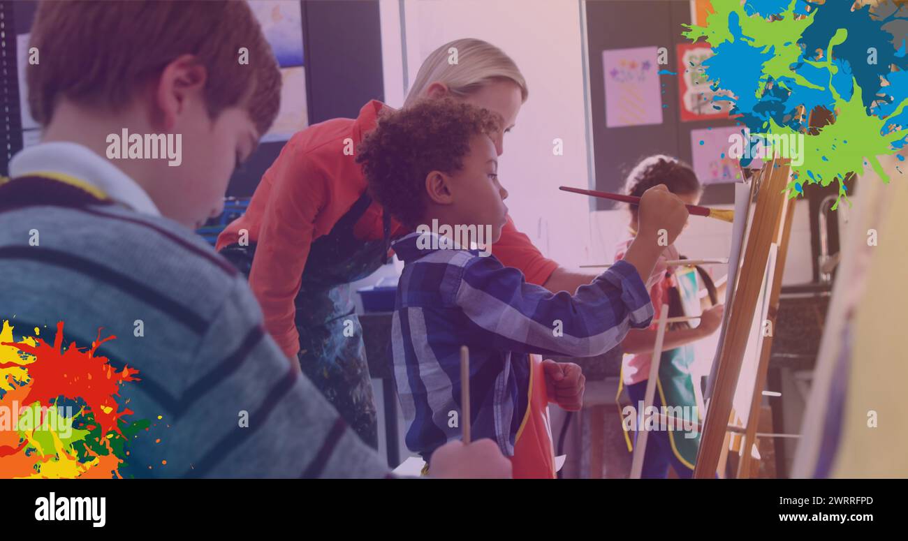 Des taches de peinture colorées contre une enseignante caucasienne enseignant aux élèves comment peindre à l'école Banque D'Images