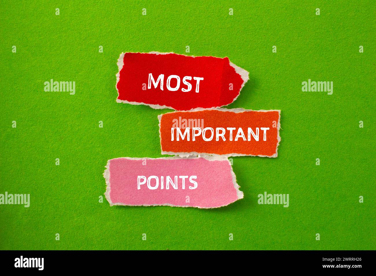Points les plus importants mots écrits sur des morceaux de papier déchirés avec fond vert. Symbole conceptuel. Copier l'espace. Banque D'Images