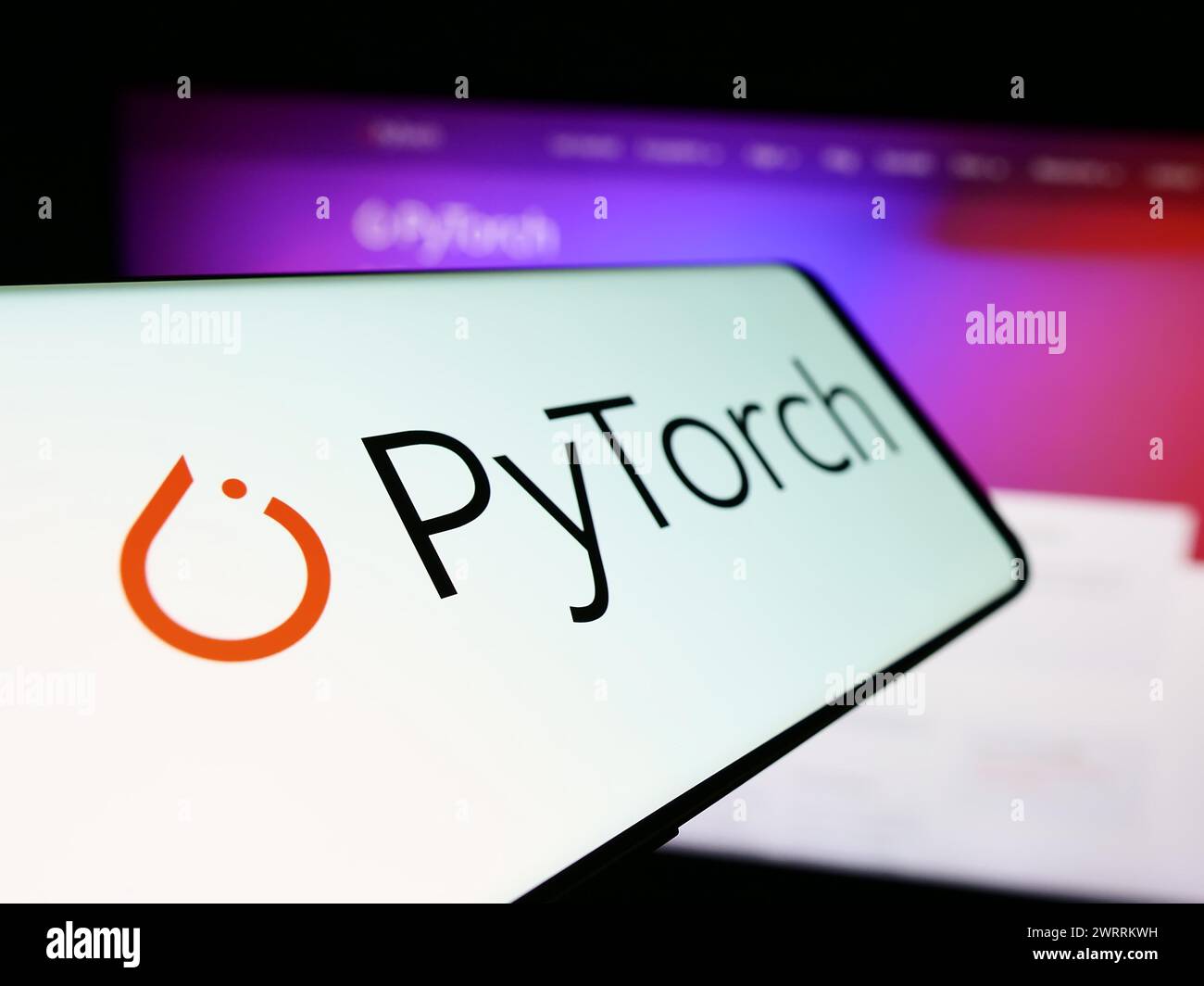 Téléphone portable avec logo de la bibliothèque d'apprentissage machine PyTorch en face du site Web. Focus à gauche de l'écran du téléphone. Banque D'Images