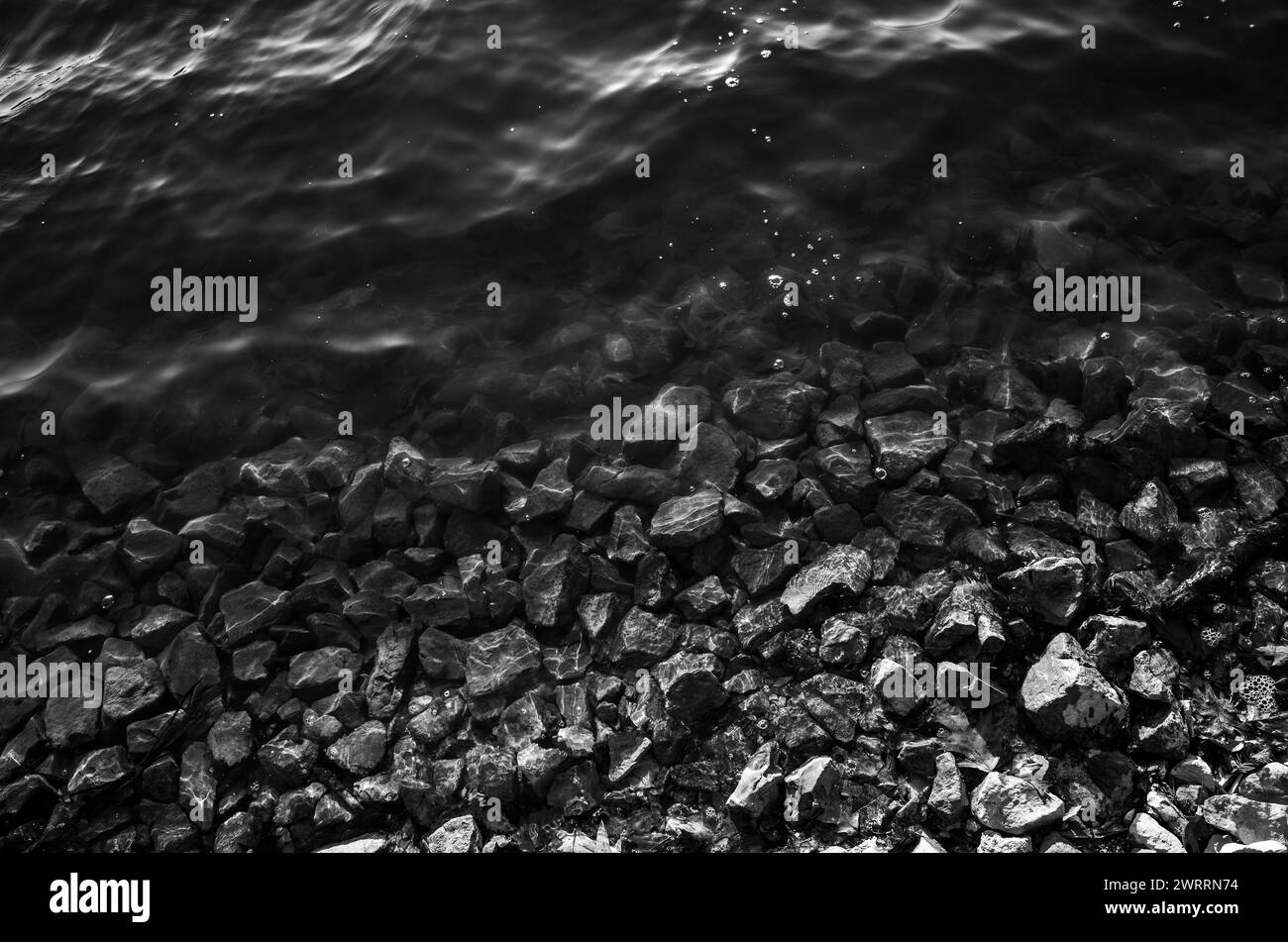 La lumière du soleil se reflétant sur les rochers dans l'eau de l'étang Banque D'Images