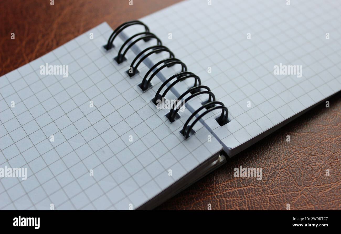 Carnet en spirale ouvert sur la table en cuir photo stock détaillée Banque D'Images
