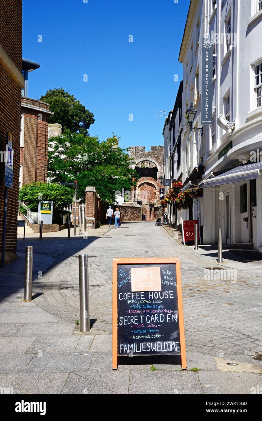 Vue le long de Castle Street vers les ruines de la maison de garde du château de Rougemont avec un signe de café au premier plan, Exeter, Devon, UK, Euroe. Banque D'Images
