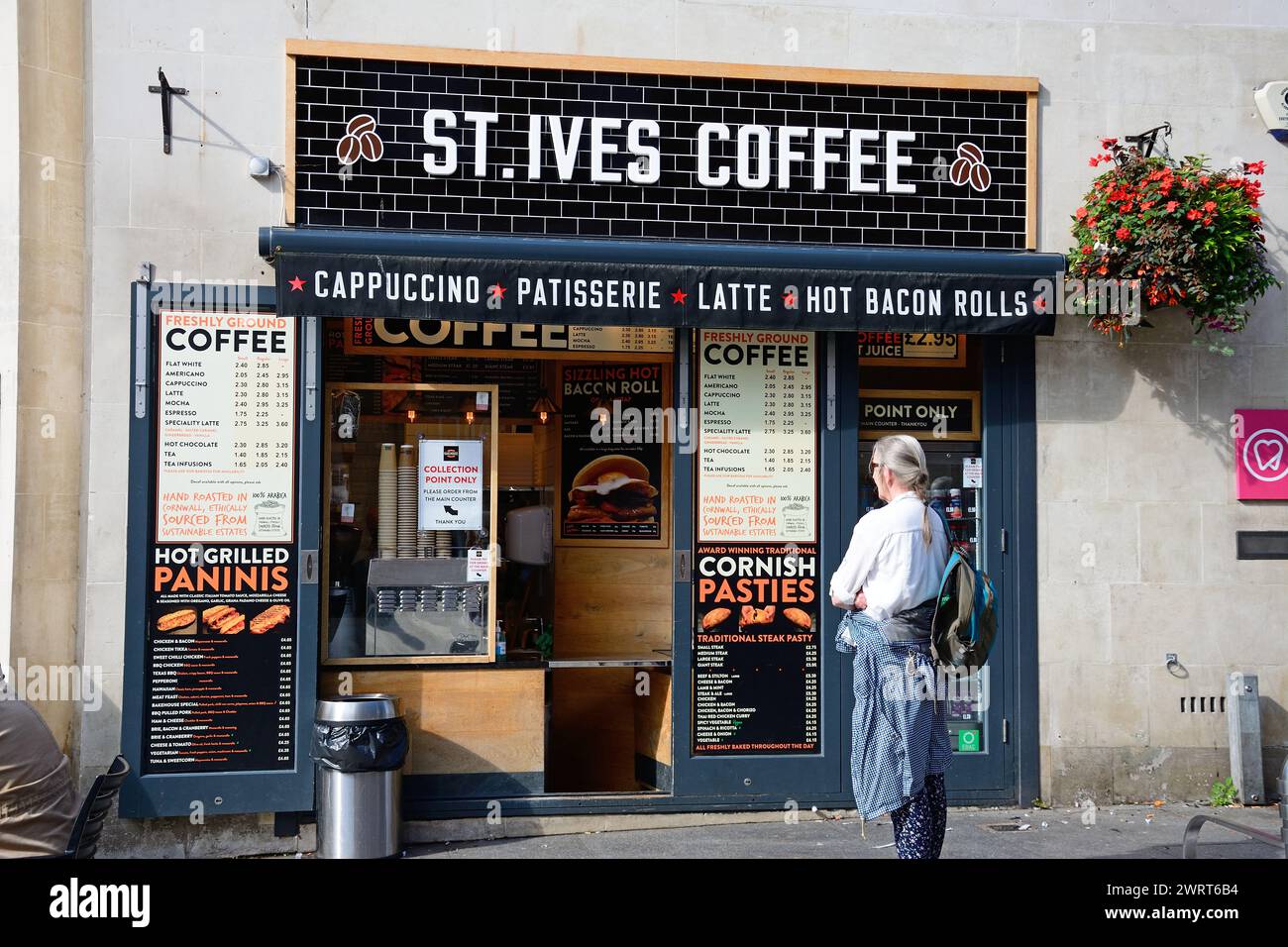 Vue de face du café St Ives avec une femme au premier plan le long de High Street dans le centre-ville, Exeter, Devon, Royaume-Uni, Europe. Banque D'Images