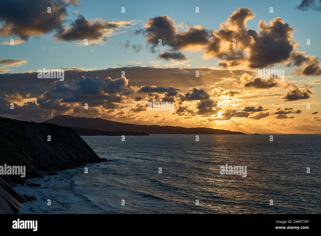 Au bord des falaises abruptes et accidentées du golfe de la baie de biscaye près de parfait Jean de Luz à la frontière entre la France et l'Espagne avec coucher de soleil spectaculaire et Banque D'Images