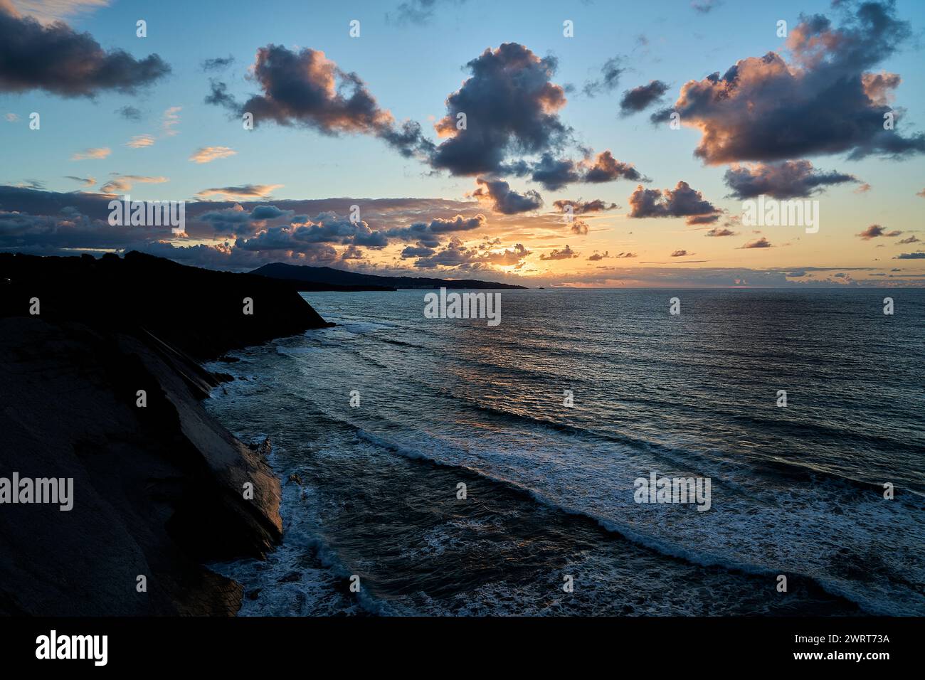 Au bord des falaises abruptes et accidentées du golfe de la baie de biscaye près de parfait Jean de Luz à la frontière entre la France et l'Espagne avec coucher de soleil spectaculaire et Banque D'Images