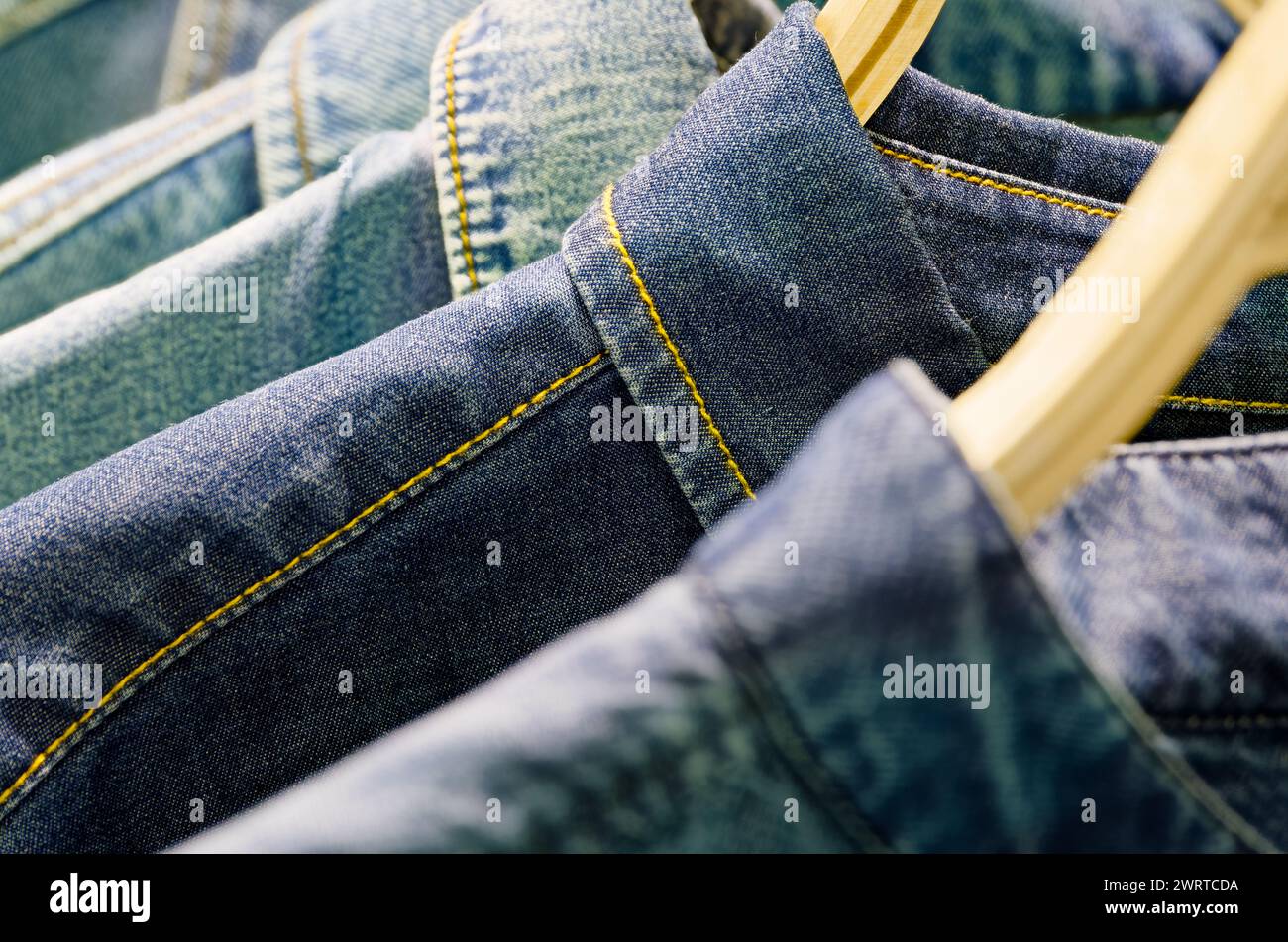 Groupe de vestes ou chemises en denim bleu sur un cintre de vêtements dans une garde-robe Banque D'Images