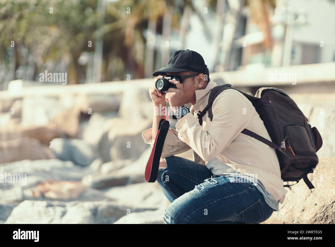 Les touristes utilisent la caméra pour photographier le coucher du soleil sur la plage. backpacker et concept de voyage. Banque D'Images