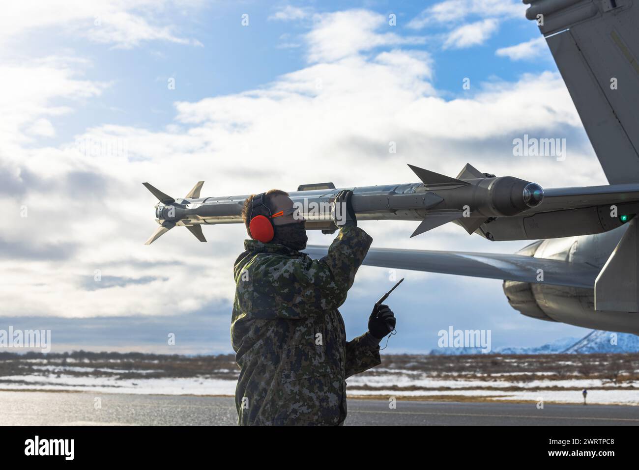 Un agent de maintenance de l'armée de l'air finlandaise désarme un F/A-18C Hornet de l'armée de l'air finlandaise tout en effectuant un ravitaillement au sol avec Marine AE Banque D'Images