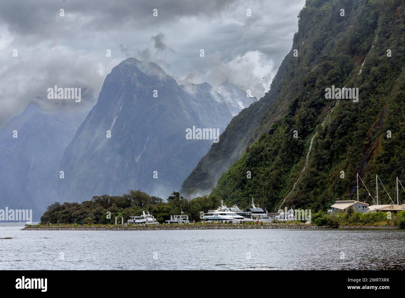 L'extrémité sud du spectaculaire Milford Sound, l'un des endroits les plus humides de la planète, est vue sous un ciel typiquement lourd à Fiordland, en Nouvelle-Zélande. Banque D'Images